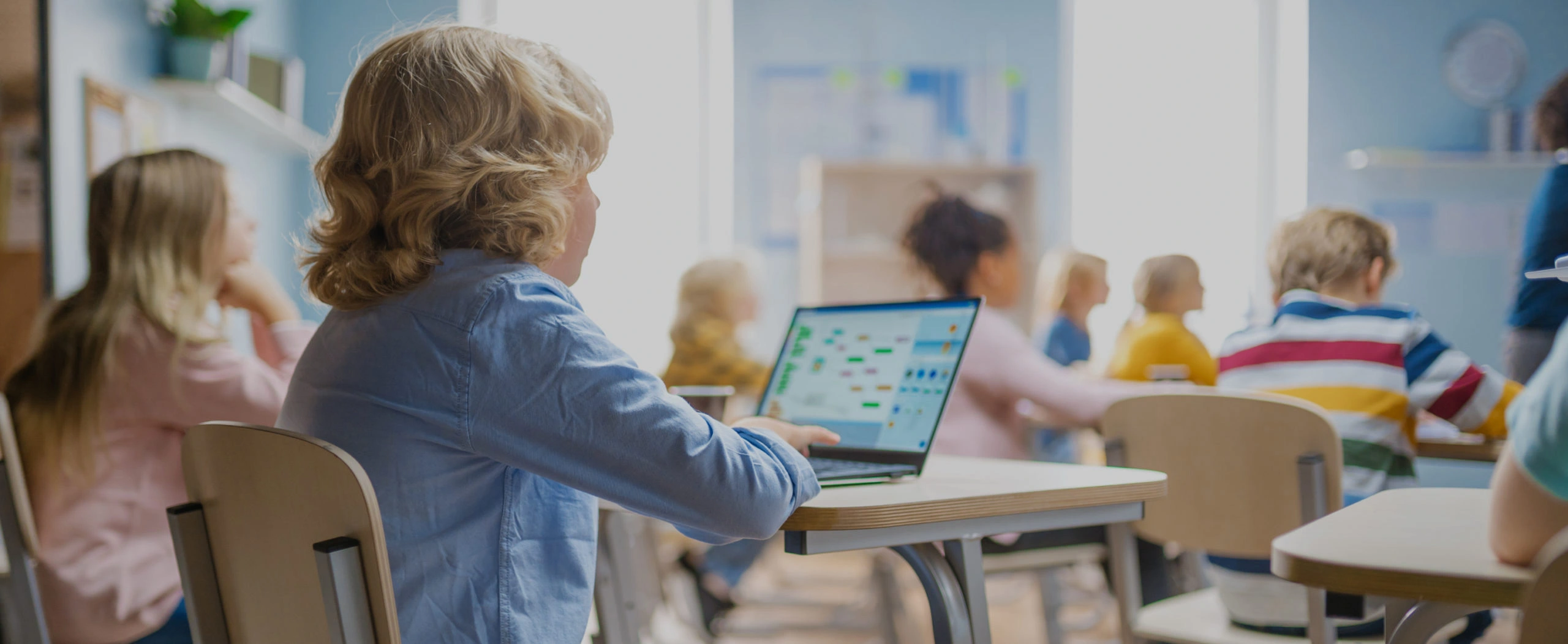 Banner-homepagina-Het-Onderwijsbureau-BV Leerlingen in een basisschoolklas die werken op laptops, onderwijs in de praktijk
